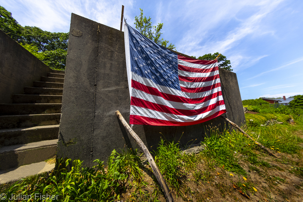 American Flag in front of brick buildings