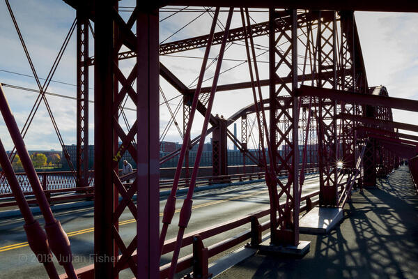 man walking across a bridge