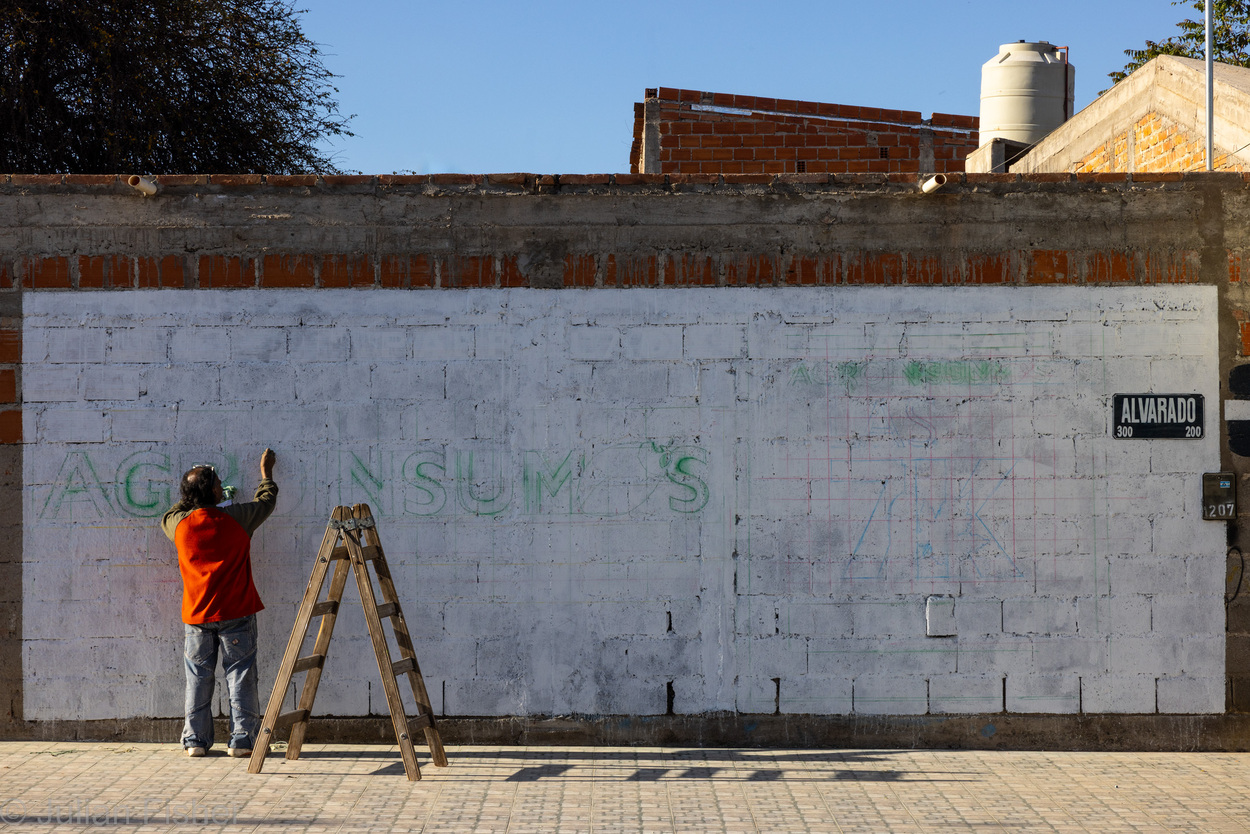 man painting a brick wall
