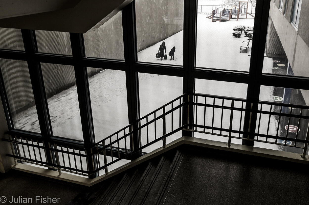 view from office stairway of two people in the snow