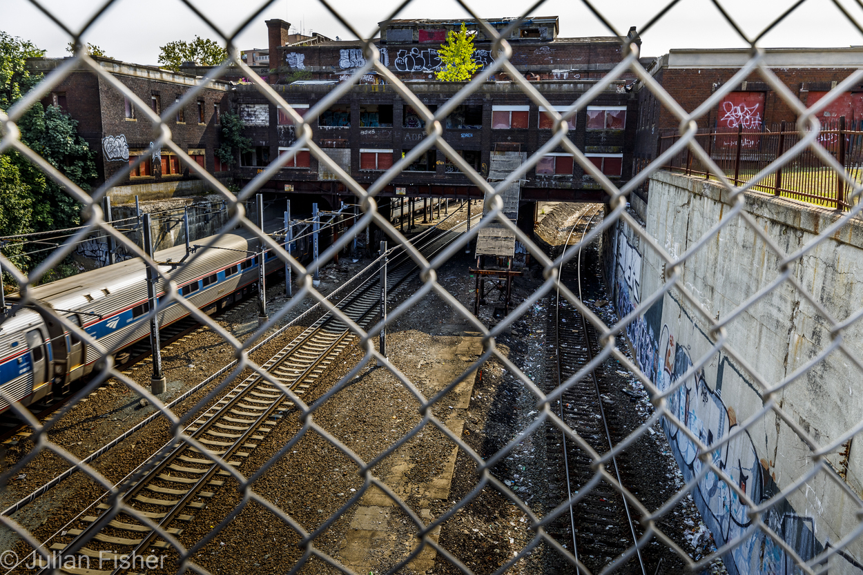 train tracks through chain link fence