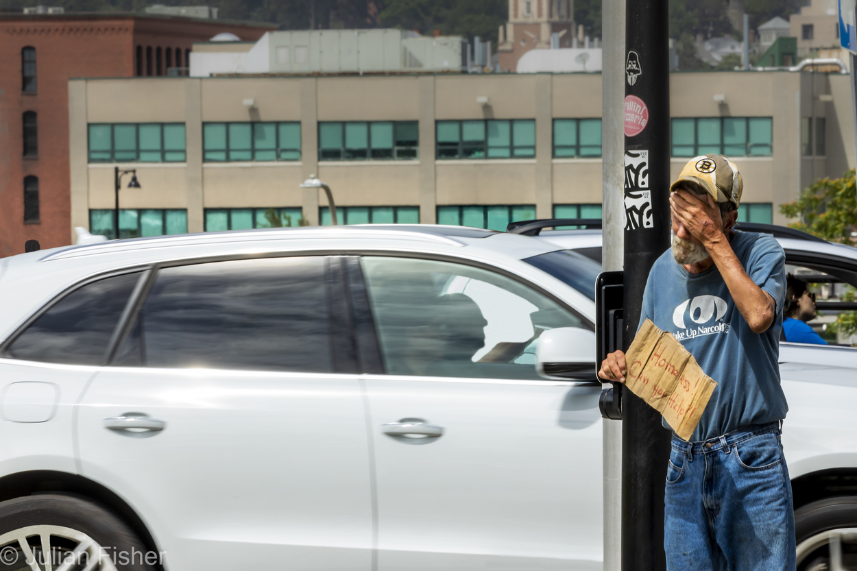 homeless man holding his head