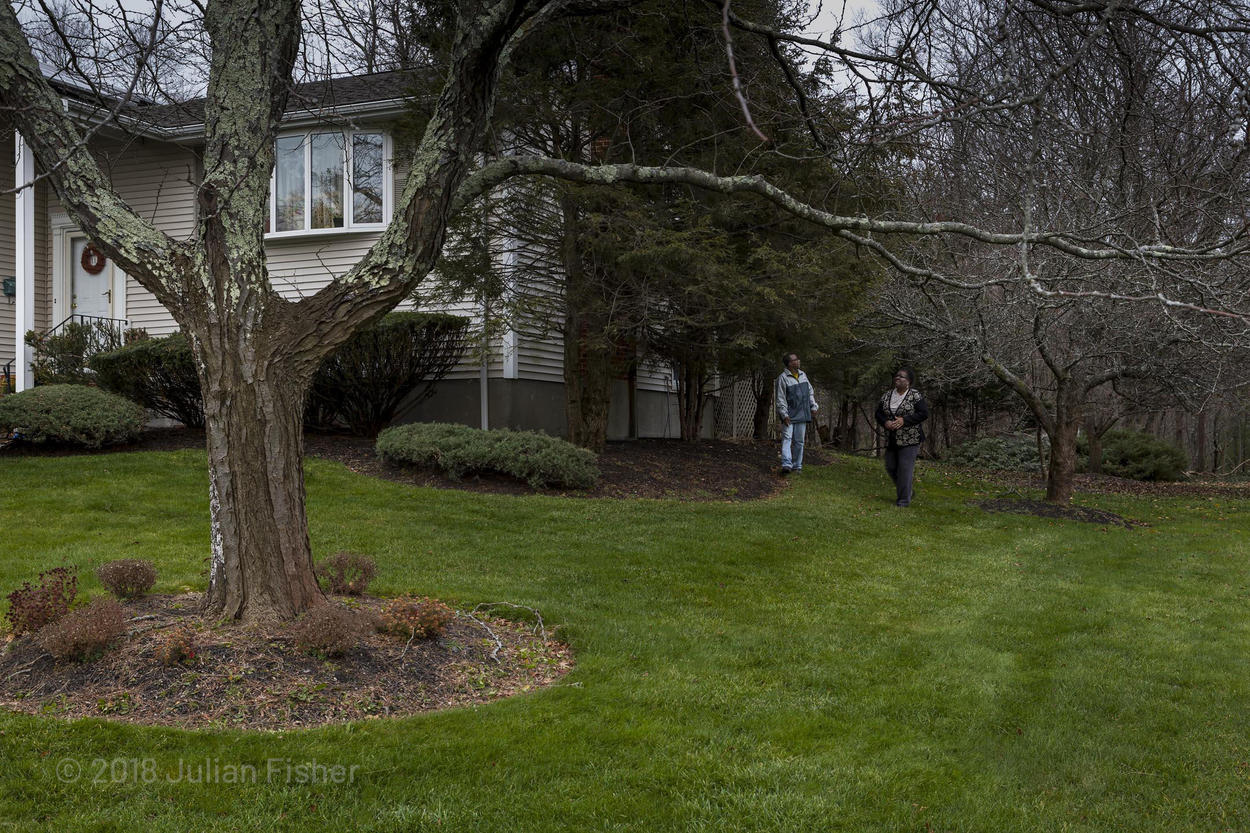 man and woman walk in their yard